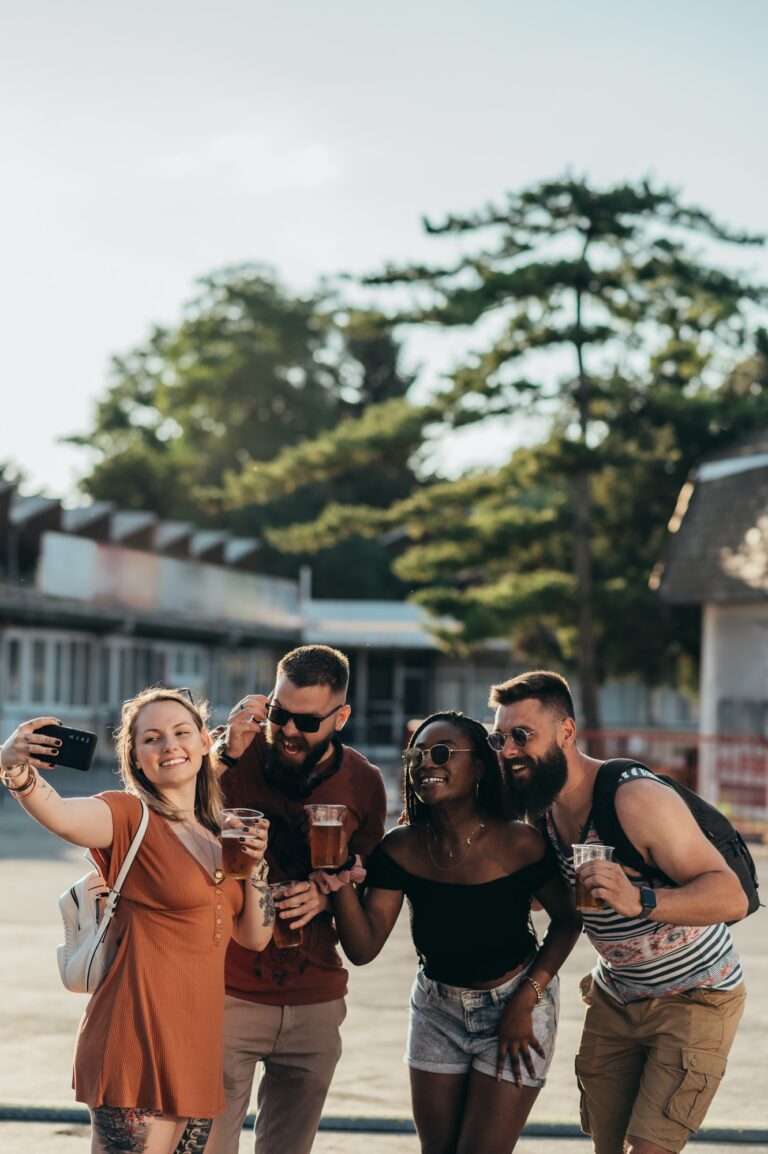 Group of friends taking selfie with a smartphone on a music festival